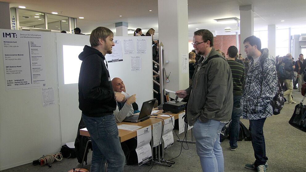 Foto (Lena Schäfer): Dominic Weiß (vorne links) und Florian Würminghausen (hinten am Tisch) mit Studenten.