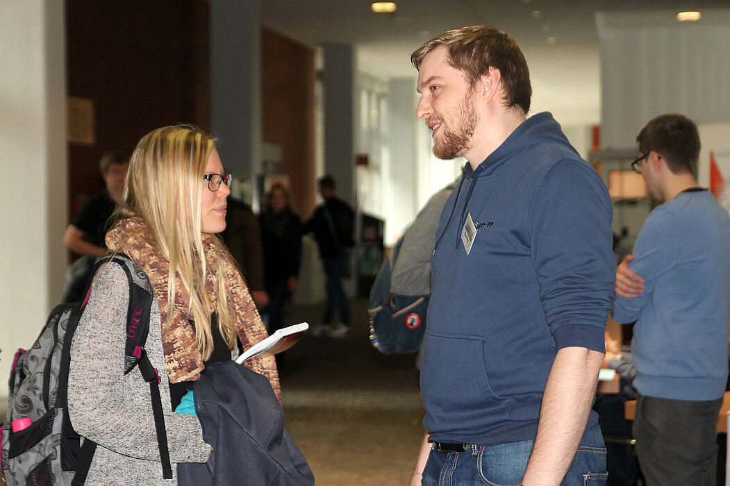 Foto (Lena Schäfer): Dominic Weiss (r.) im Gespräch mit einer Studentin.